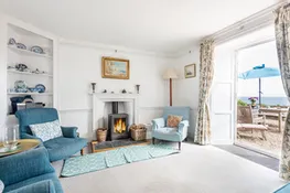 The lounge with log burner and doors opening out onto the terrace overlooking the sea