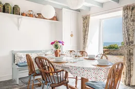 The dining area in the spacious kitchen diner, with views to the terrace and sea beyond