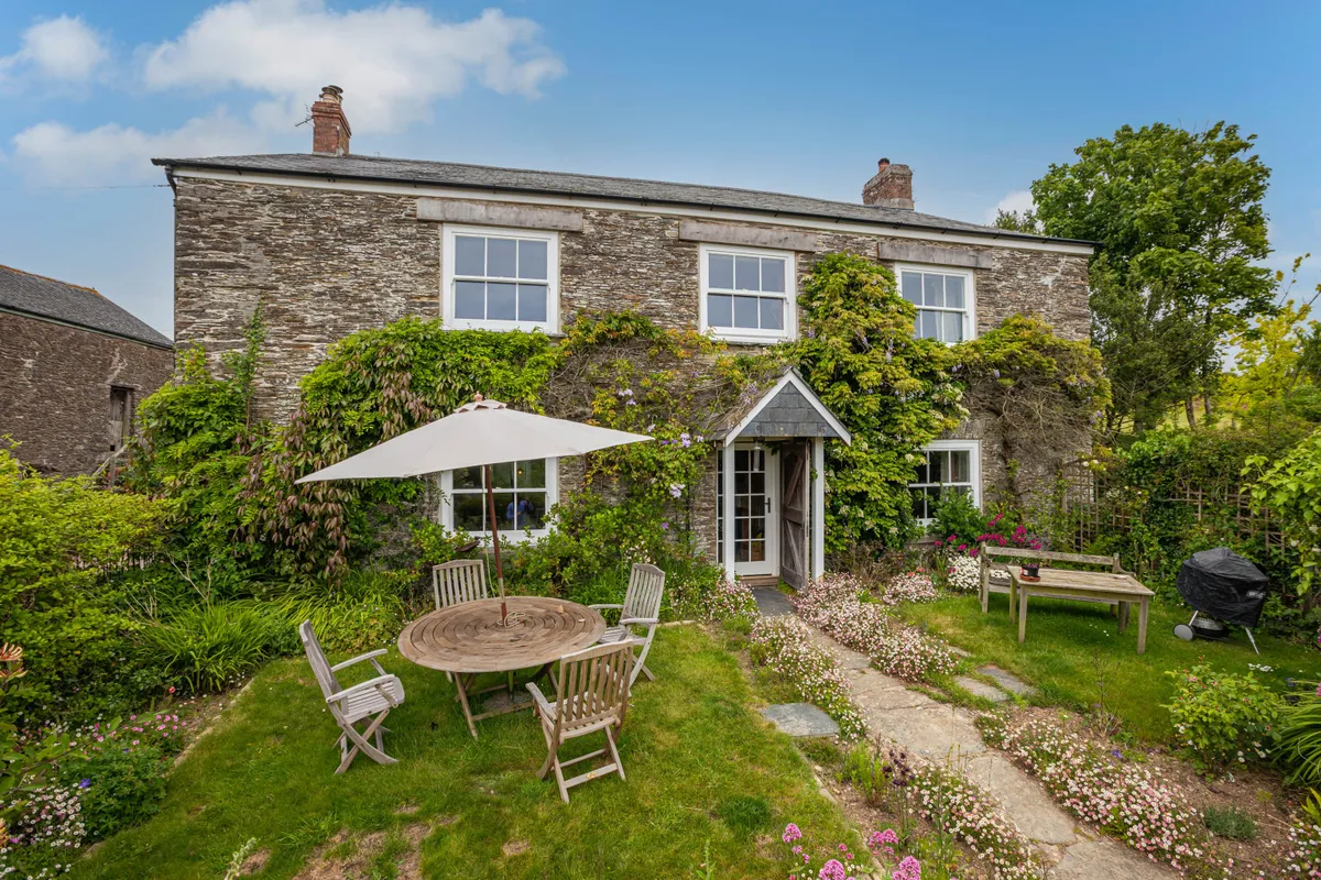 The front lawn with table and chairs and a barbecue