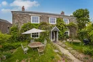 The front lawn with table and chairs and a barbecue