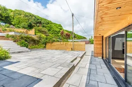 A view of the large rear terrace with the higher terrace in view.