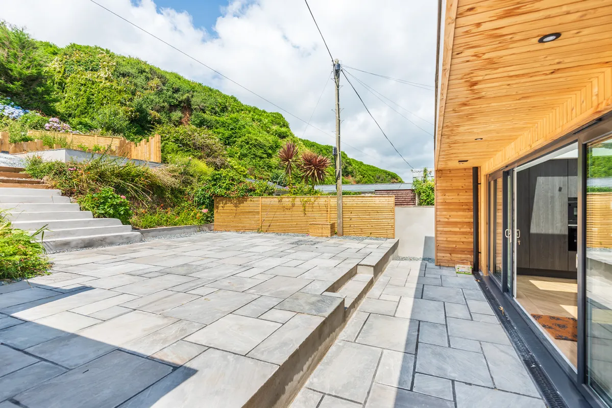 A view of the large rear terrace with the higher terrace in view.