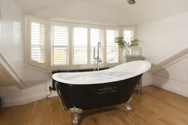 Roll top bath in master bedroom - Happy Days Cottage